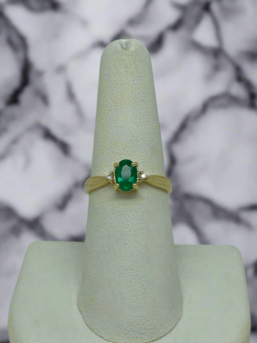 yellow gold ring with oval emerald center and diamond accents