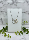 yellow and white gold necklace of two interlocking circles, one set with diamonds