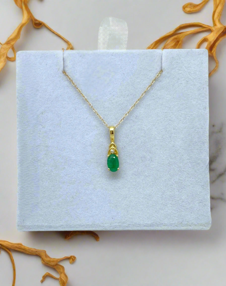 yellow gold necklace with oval emerald stone and diamond accent