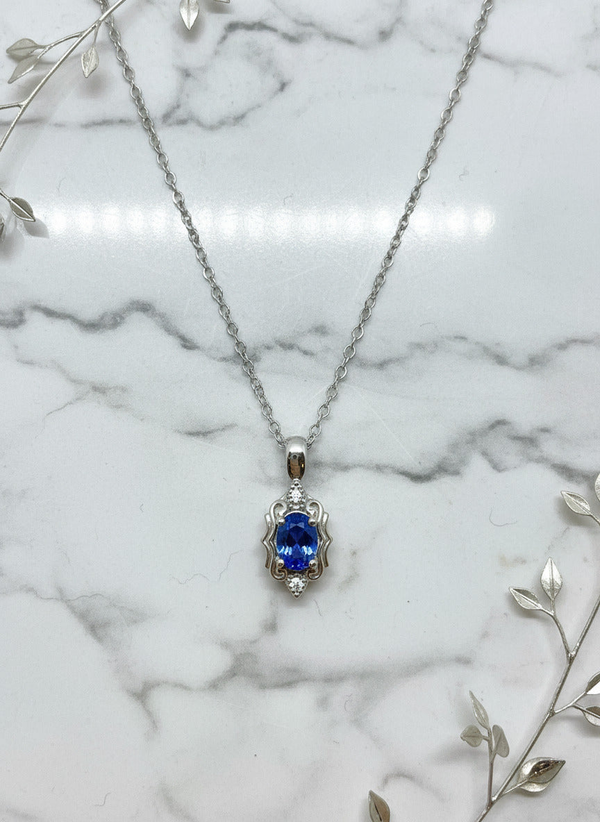 white gold vintage style pendant and chain with oval blue sapphire and diamond accents