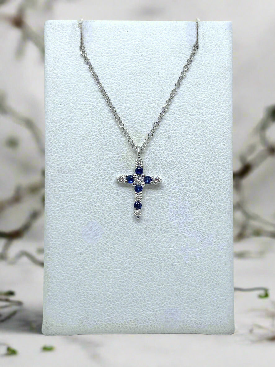 white gold necklace with cross pendant set with 5 round blue sapphires and 6 diamonds