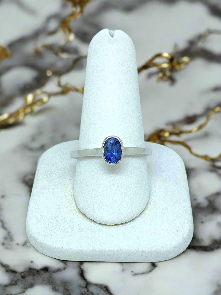 white gold ring with oval bezel-set blue sapphire