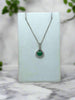 white gold necklace with emerald center stone and diamond halo