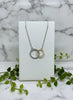 yellow and white gold necklace of two interlocking circles, one set with diamonds