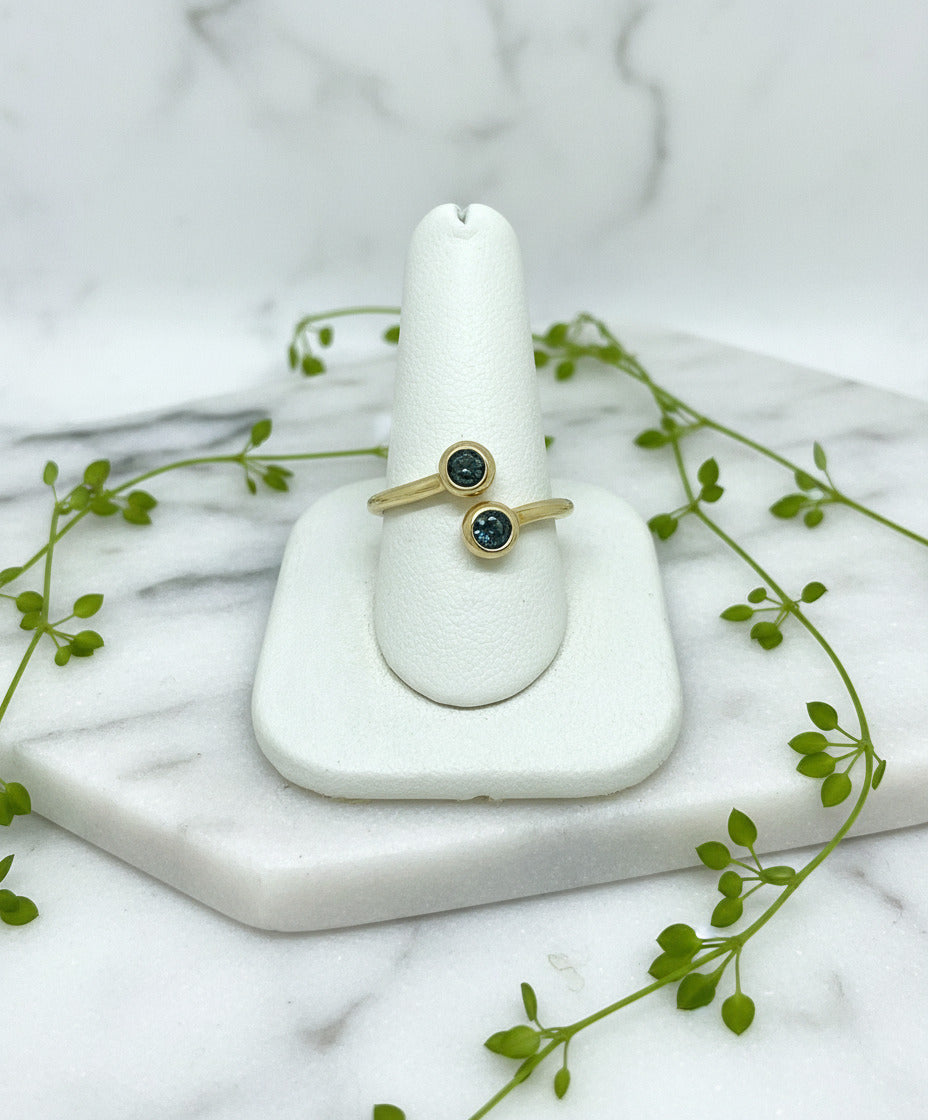 14 karat yellow gold open bypass ring with two round blue sapphires