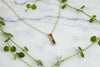 yellow gold chain with bar pendant set with descending rainbow colored sapphires