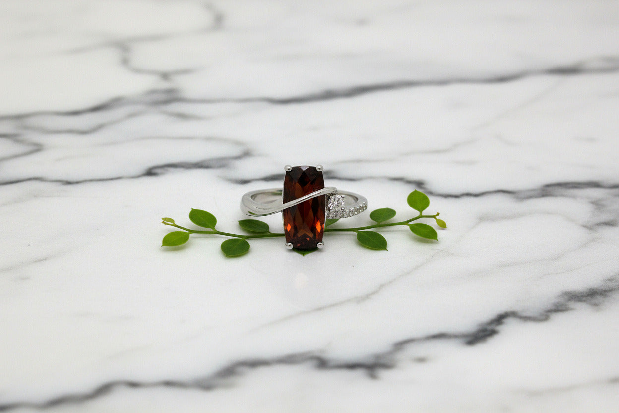 white gold ring with barrel-cut garnet and diamond accents