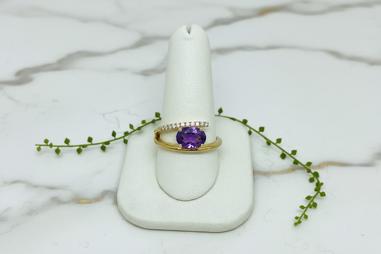 yellow gold ring with oval amethyst set east-west and asymmetric line of diamonds