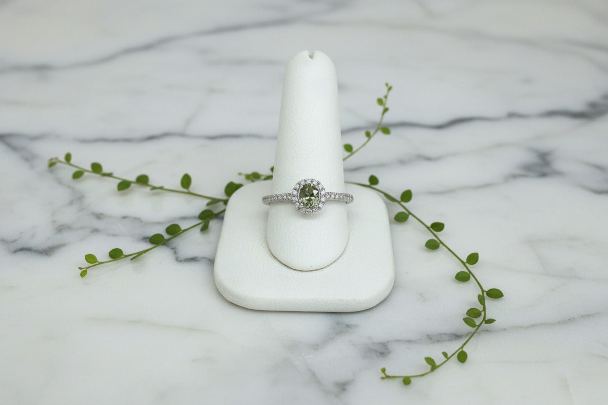 white gold ring set with diamonds and a center stone that is an oval color changing natural alexandrite