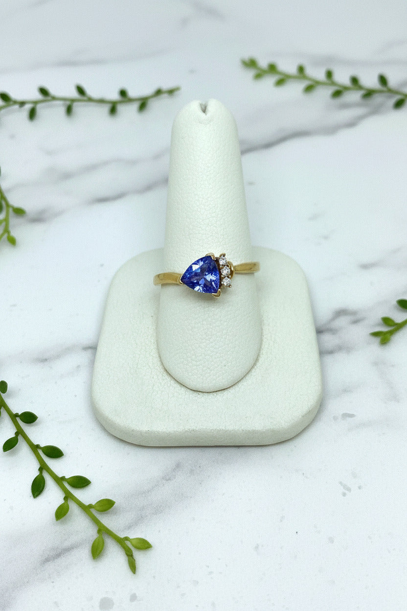 yellow gold ring with asymmetrically set trillion cut tanzanite with 3 diamond accents