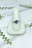 yellow gold ring with asymmetrically set trillion cut tanzanite with 3 diamond accents