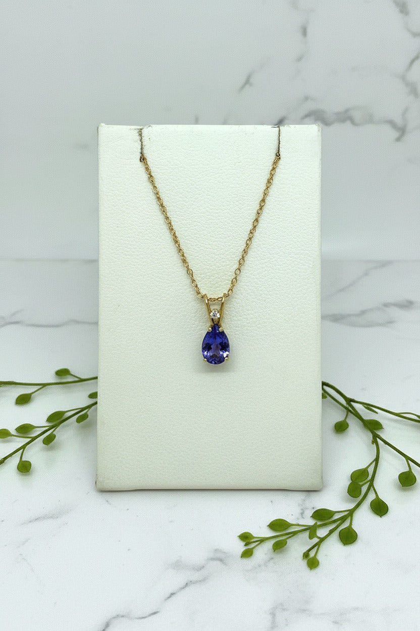 yellow gold chain and pendant set with pear shape tanzanite with diamond accent