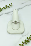 white gold ring set with round natural alexandrite in center and diamond halo as well as accent diamonds down the band