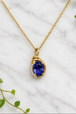 yellow gold necklace and pendant. pendant is set with an oval iolite center and accented with a ribbon of diamonds along one edge.