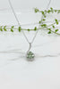 white gold chain and pendant with ribbon of diamonds curling around a trillion cut prasolite