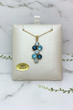 yellow gold necklace and pendant set with various shades of blue topaz and blue zircon