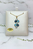 yellow gold necklace and pendant set with various shades of blue topaz and blue zircon