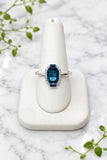 14 karat white gold ring with center london blue topaz, 2 baguette sapphires, and diamonds